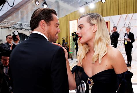 Margot Robbie hugs ex co-star Leonardo DiCaprio in touchy-feely reunion as her husband looks on ...