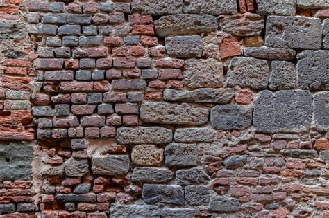 Premium Photo | Fragment of wall made of stone blocks and bricks of various size and shape ...