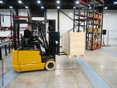 Forklift truck warehouse. Yellow forklift truck with wooden crate. Man ...