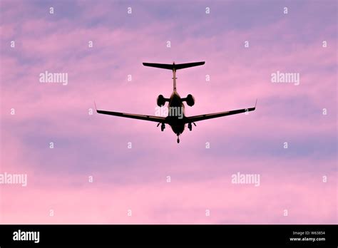 Business jet is landing on sunset or sunrise silhouette Stock Photo - Alamy