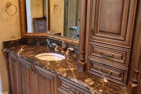 a bathroom with marble counter tops and wooden cabinets
