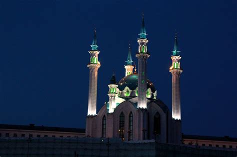 two tall towers lit up at night with lights on them and the sky in the background