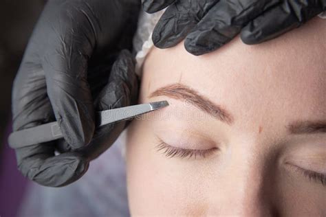 Young Woman Plucking Eyebrows with Tweezers Close Stock Photo - Image ...