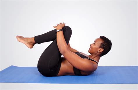 Flexible woman doing yoga stretch at lying on yoga mat