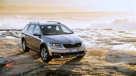 a car parked on top of a rocky beach next to the ocean with waves in ...