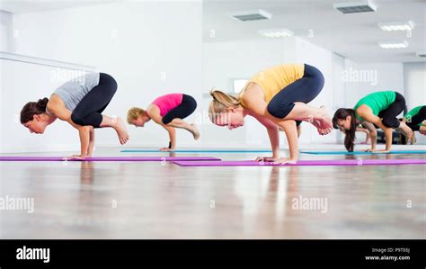 Four girls practicing yoga, Bakasana / Crane pose Stock Photo - Alamy