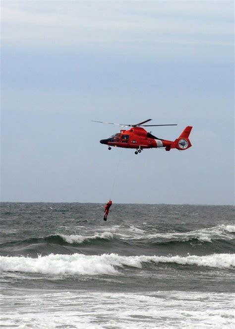 A Coast Guard MH-65 Dolphin helicopter crew from Air Station North Bend, Ore, retrieves a rescue ...