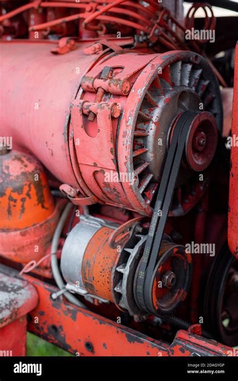 Closeup of four cylinder diesel tractor engine with visible belt rusty tracks hydraulic parts ...