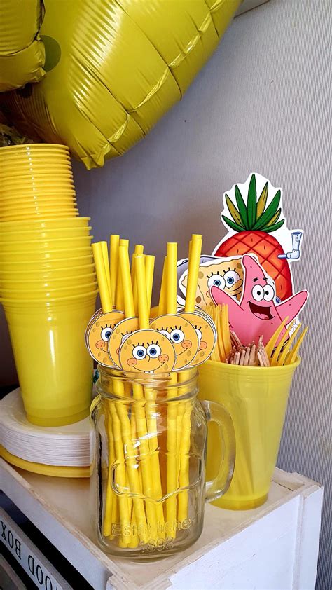 there are many yellow straws and cups on the table