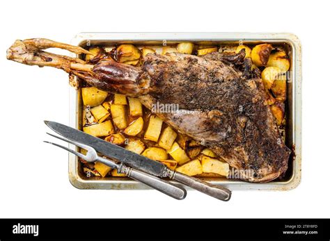 Roast lamb mutton leg with potatoes and rosemary in baking dish. Isolated, white background ...