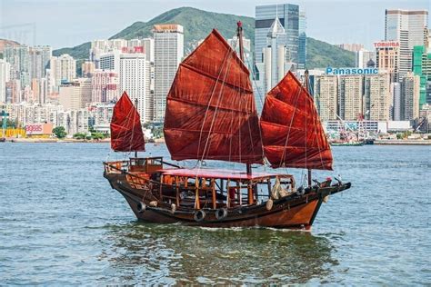 Traditional Chinese junk sailing at Victoria harbour in Hong Kong, China - Stock Photo - Dissolve