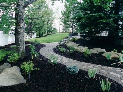 Black Mulch complimenting the Charcoal Cobblestone | Mulch landscaping, Backyard landscaping ...