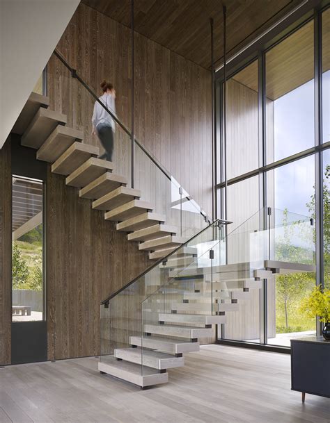 Two story Window frames an impressive Mountain view; Entry with Suspended Stair. by Robbins ...