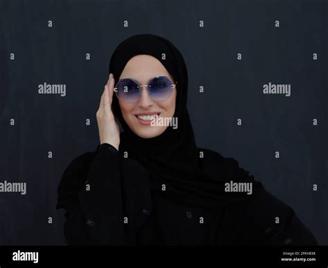Young muslim in traditional clothes or abaya and sunglasses posing in ...