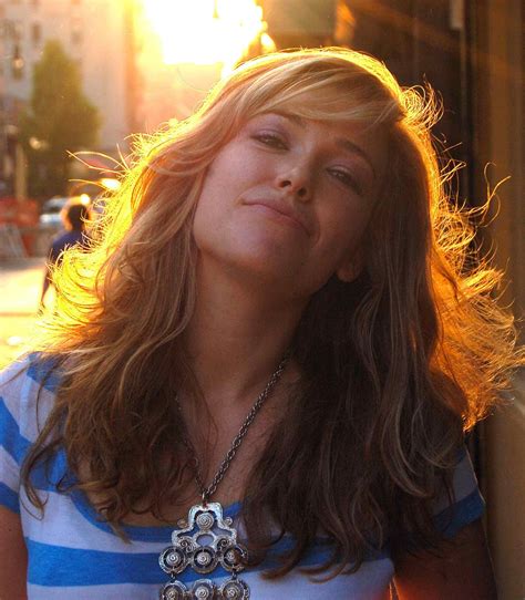 a woman with her eyes closed standing in front of a building