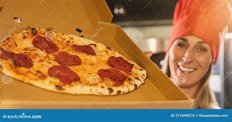 Female Pizza Baker Holding a Fresh Salami Pizza from the Stone Oven in ...