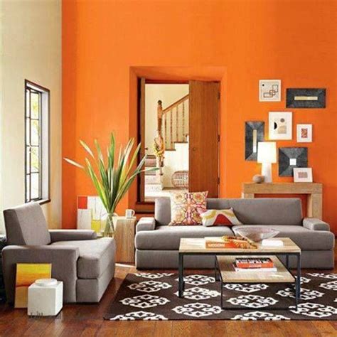 an orange living room with grey couches and white coffee table in front ...