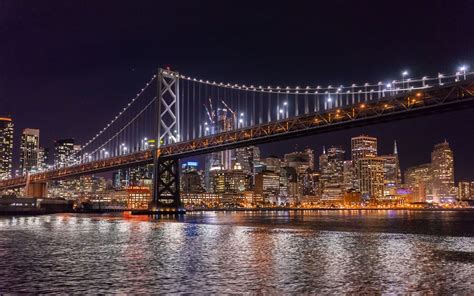 San Francisco Night Cruise - View of the San Francisco-Oakland Bay Bridge and the bright ...