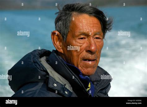 Portrait Inuit Greenlander wearing a down jacket with hood in Qinngertivaq Fjord Eastgreenland ...