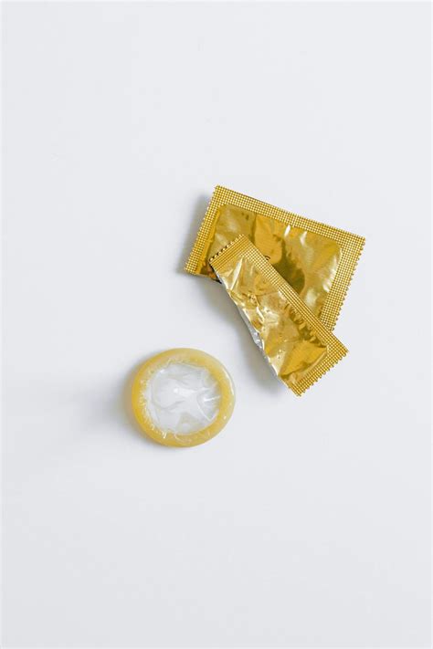Unwrapped Condom on White Surface · Free Stock Photo