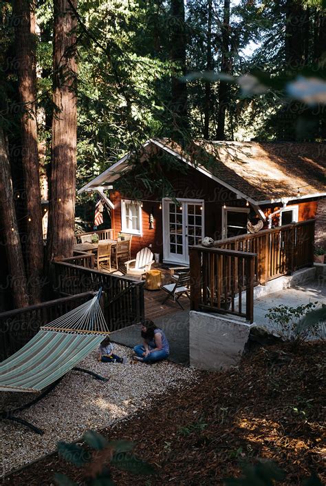 «A Mother And Son Plays In Front Of A Cute Little Cabin In The Woods.» del colaborador de ...