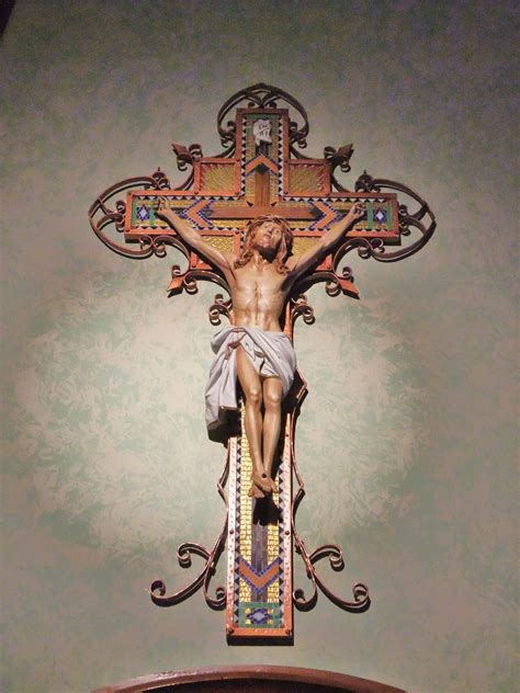 the crucifix is on display in front of a wallpapered background