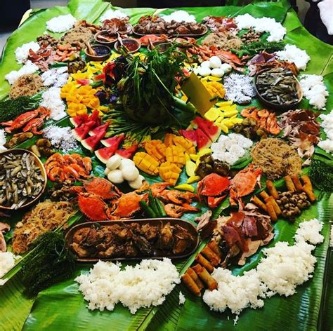 a large platter filled with lots of food on top of a green table cloth