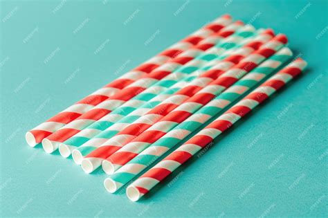 Premium Photo | Red and white striped drinking straws on a teal background
