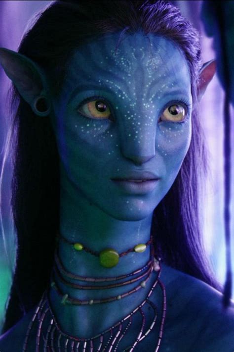 a close up of a person with blue skin and green eyes wearing necklaces ...