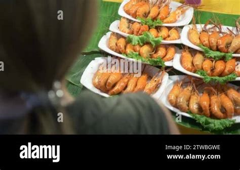 a woman looks at the products on the night market. Thai street food ...