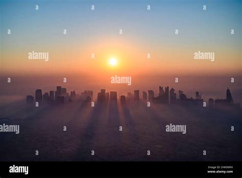 Doha skyline at sunrise with morning fog Stock Photo - Alamy