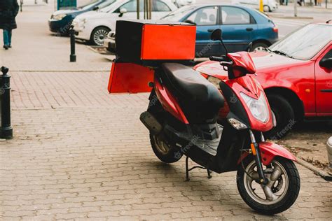 Premium Photo | Red pizza delivery motorcycle stands on the street with ...