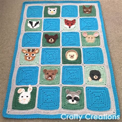 a crocheted blanket with animals on it is sitting on the floor in front ...