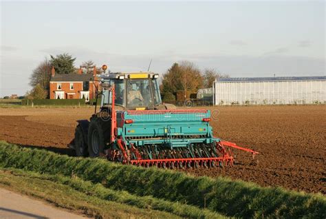 Tractor Ploughing Farm Field. Tractor pulling plough on field with farm ...