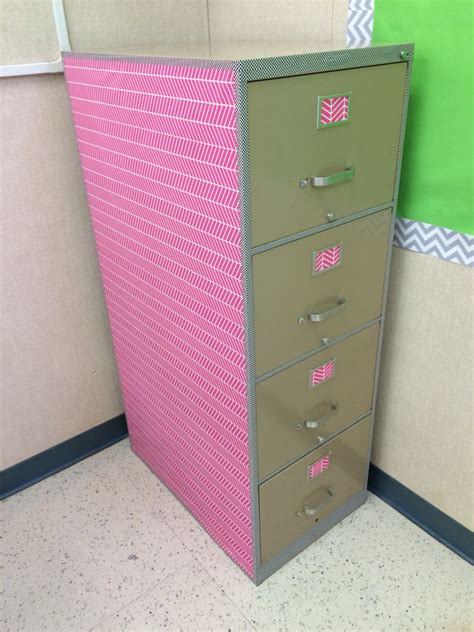 a pink file cabinet sitting in an office cubicle next to a green and white wall
