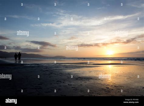 two people walking in the sunset Stock Photo - Alamy