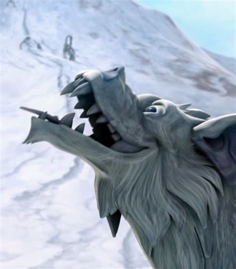 a statue of an animal with its mouth open on the side of a snowy mountain