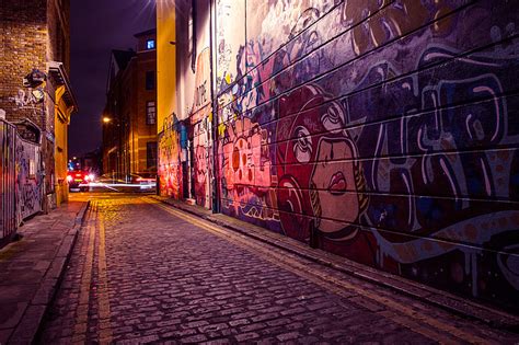 Royalty-Free photo: City side street with street art and graffiti captured by night | PickPik