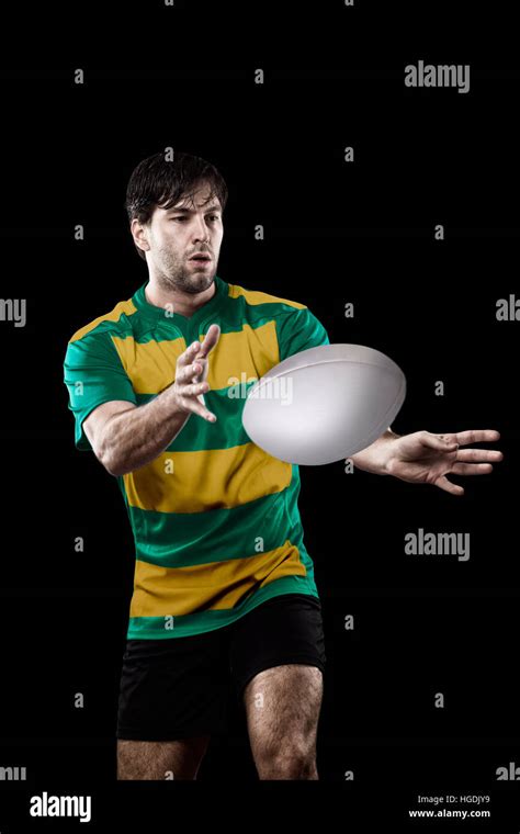 Rugby player in a green and gold uniform. black Background Stock Photo - Alamy