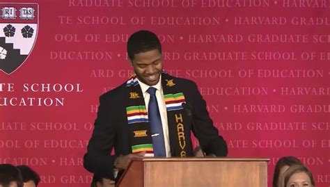 a man standing at a podium with his hands in the air