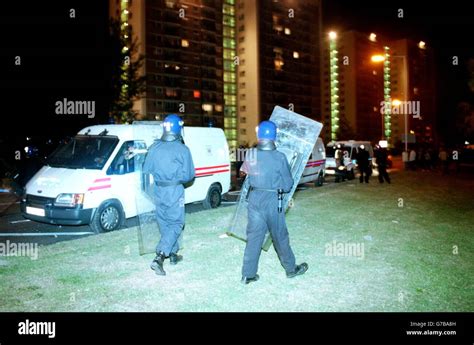 Police in riot equipment come under bombardment from missiles thrown from the block of flats in ...