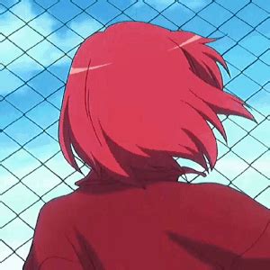 a person with red hair standing in front of a fence and looking at the sky