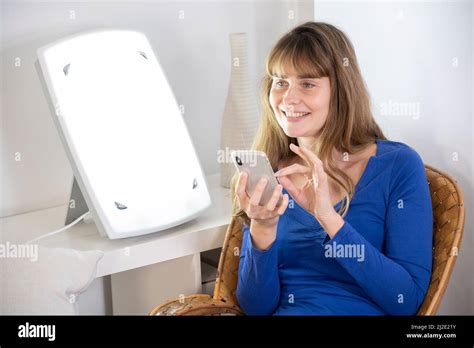 Woman smartphone light therapy Stock Photo - Alamy