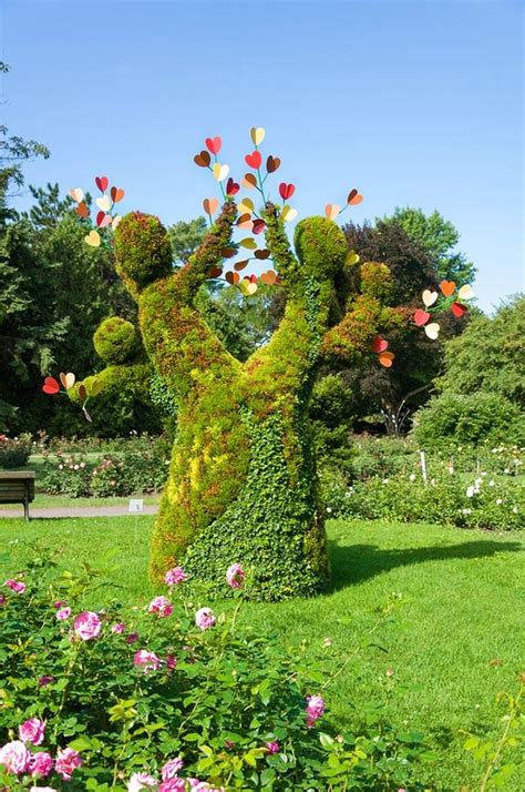 the topiary sculpture is made to look like two people holding hands and hearts in each other's arms