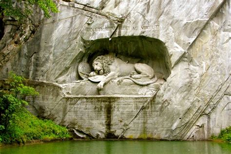 a statue of a lion on the side of a mountain