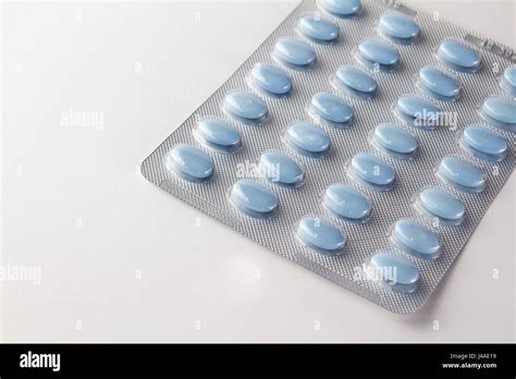 Blue oval pills in blister package on white close up Stock Photo - Alamy