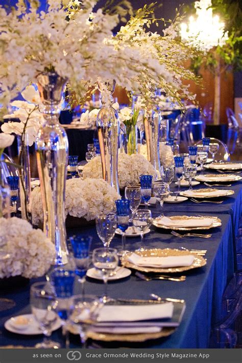 Royal blue tables with pops of gold and silver featuring phalaenopsis ...