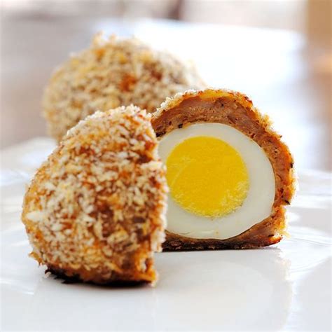 Scotch Eggs. YUM...I must try these. Eggs wrapped in sausage, dipped in egg, rolled in ...