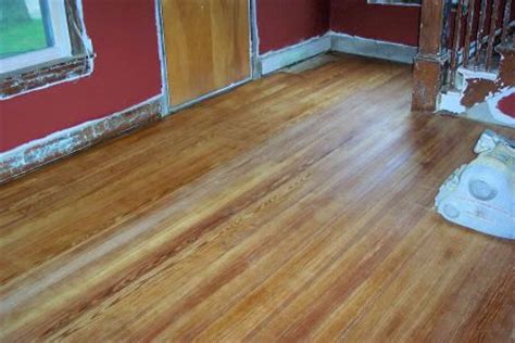 a room that has been painted red and is being worked on with wood flooring