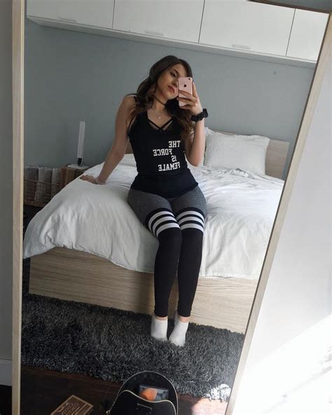 a woman taking a selfie while sitting on a bed